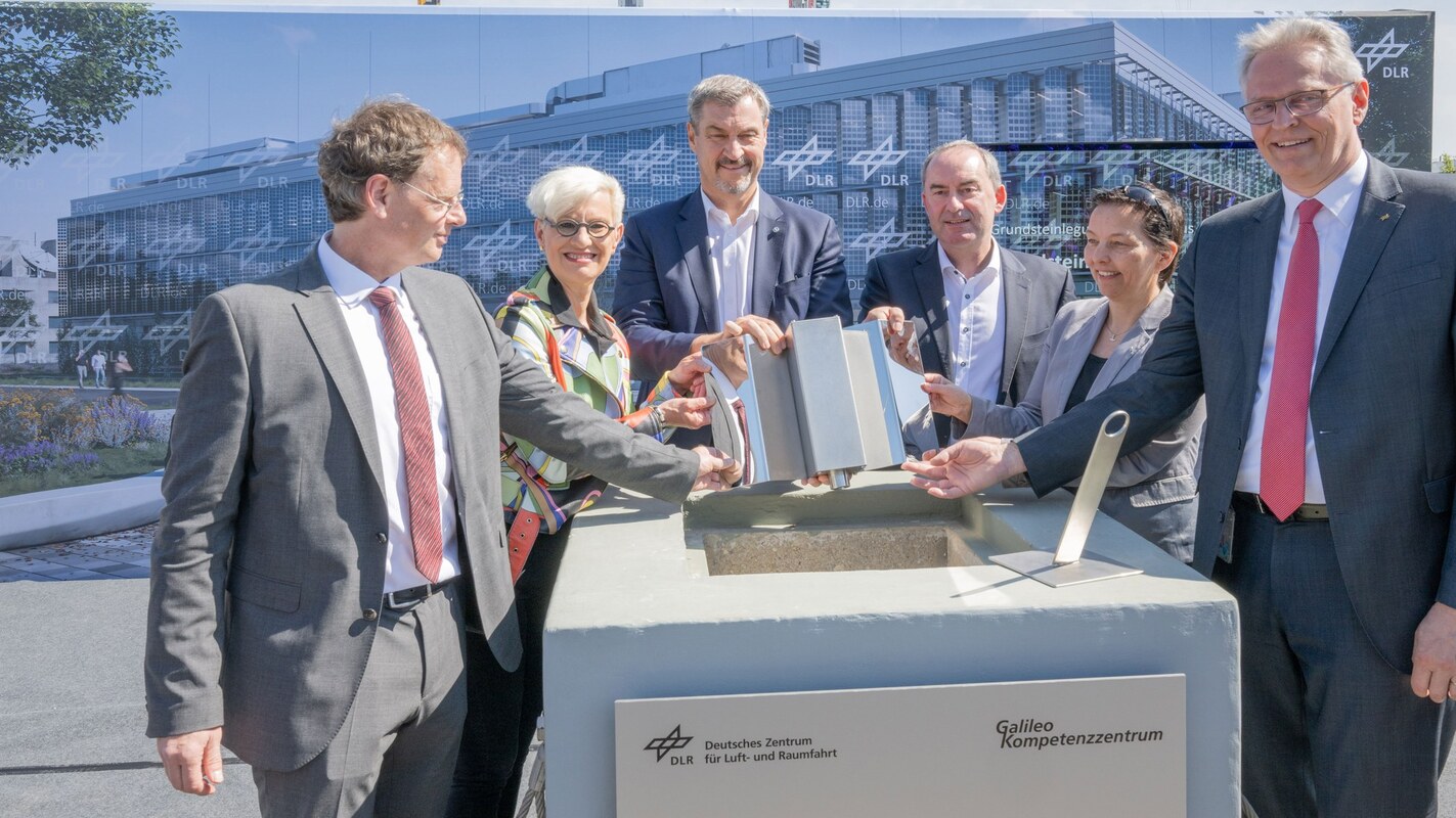 Feierliche Zeremonie zur Grundsteinlegung des Galileo Kompetenzzentrums. Am 14. Mai 2025 fand die feierliche Grundsteinlegung für das Gebäude des DLR Galileo Kompetenzzentrums in Oberpfaffenhofen statt. Die traditionelle Zeitkapsel (Bildmitte) der Zeremonie wurde der Form eines Galileo-Satelliten nachempfunden. Im Bild (von links): Harald Hofmann, DLR-Einrichtungsleiter Galileo Kompetenzzentrum, Prof. Anke Kaysser-Pyzalla, DLR-Vorstandsvorsitzende, Dr. Markus Söder, Bayerischer Ministerpräsident, Hubert Aiwanger, Bayerischer Staatsminister für Wirtschaft, Landesentwicklung und Energie, Dr. Anke Pagels-Kerp, DLR-Bereichsvorständin Raumfahrt, und Prof. Karsten Lemmer, DLR-Vorstandsmitglied für Innovation, Transfer und wissenschaftliche Infrastrukturen. Bild: DLR (CC BY-NC-ND 3.0).